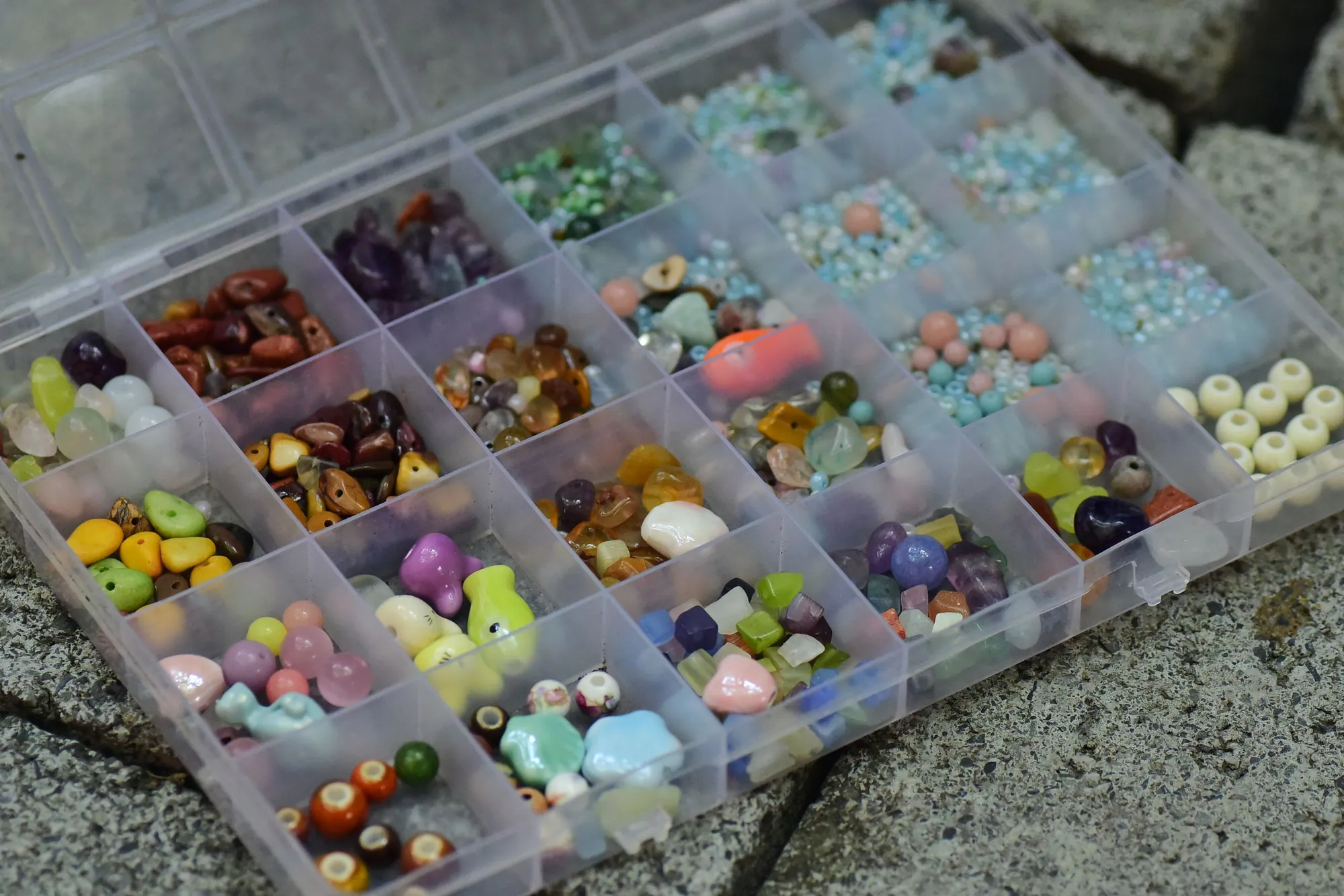 Craft beads sorted in a storage box — one compartment per color